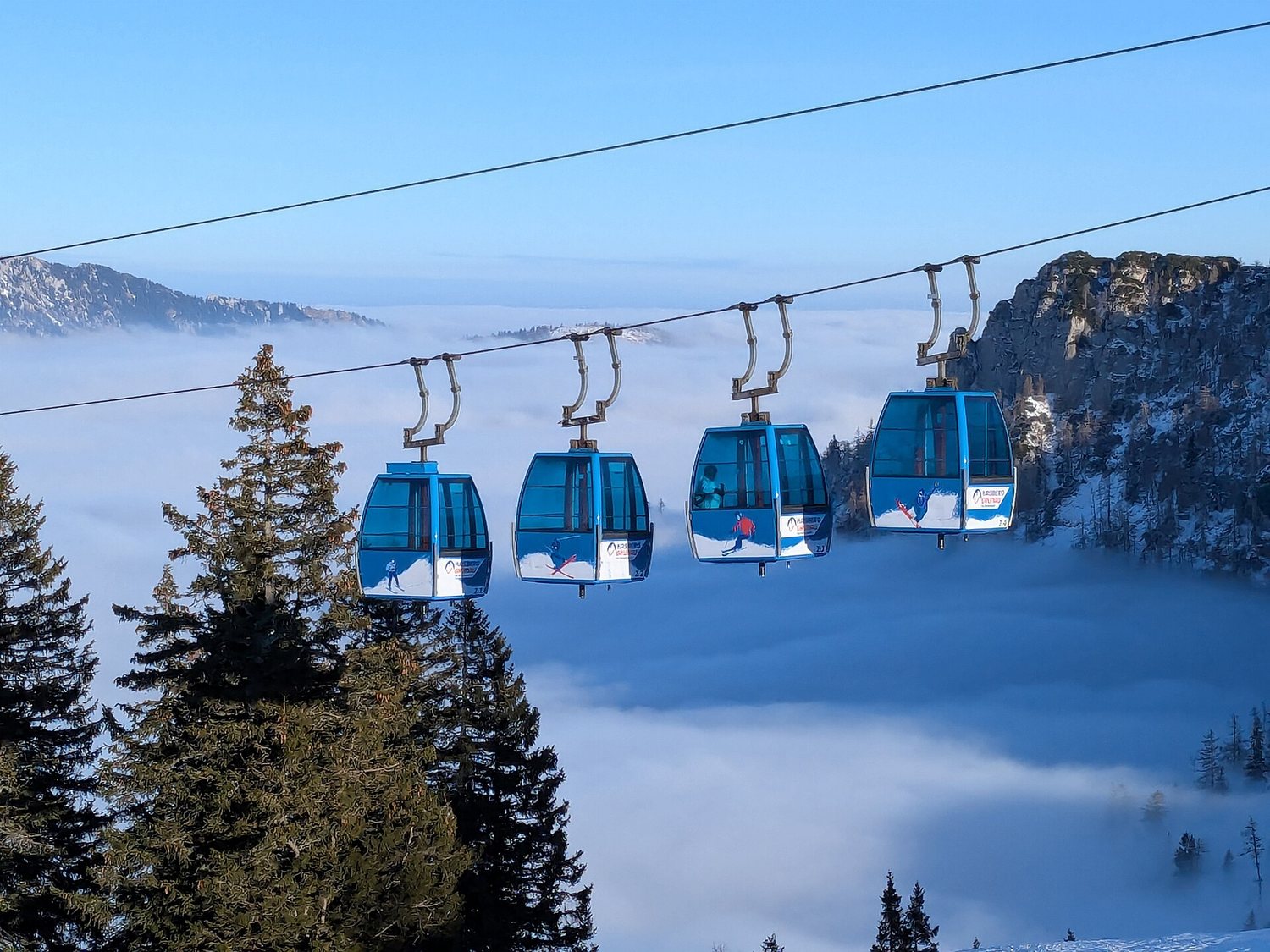 Kabinky lanovky na Kasbergu nad inverzní mlhou v údolí Almtal