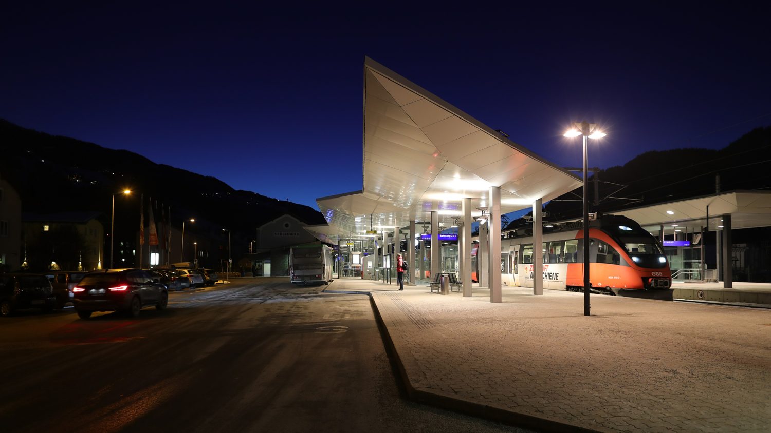 Nádraží Schladming večer s regionálním vlakem ÖBB u nástupiště